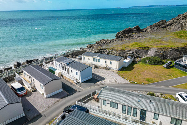 Aerial view of coastal holiday homes by UK property photographer, showcasing North Wales landscape and ocean.
