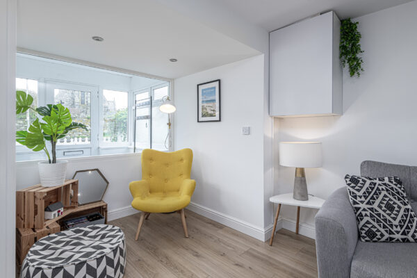 Modern interior living space captured by UK property photographer, North Wales. Cozy chair, stylish decor.