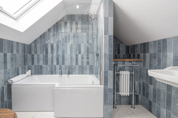 Modern bathroom photographed by UK property photographer, featuring sleek blue tiles. North Wales photographer.