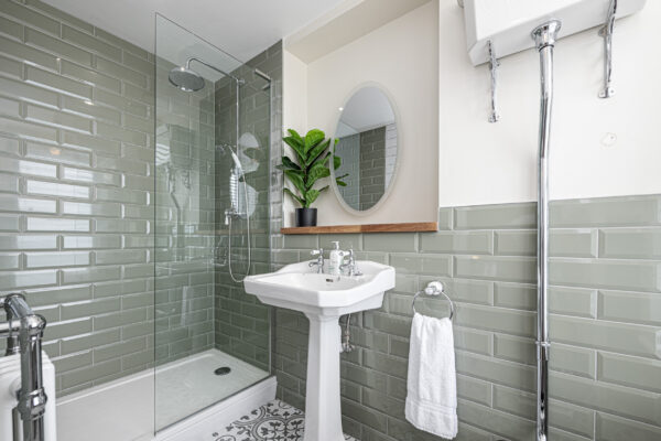 Stylish bathroom with green tiles by UK property photographer, North Wales. Elegant design and modern features.
