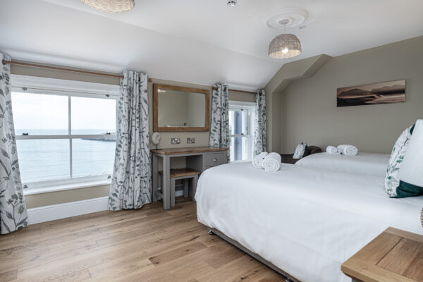Elegant bedroom with sea view by UK property photographer, North Wales. Professional interior photography highlighting scenic vistas.
