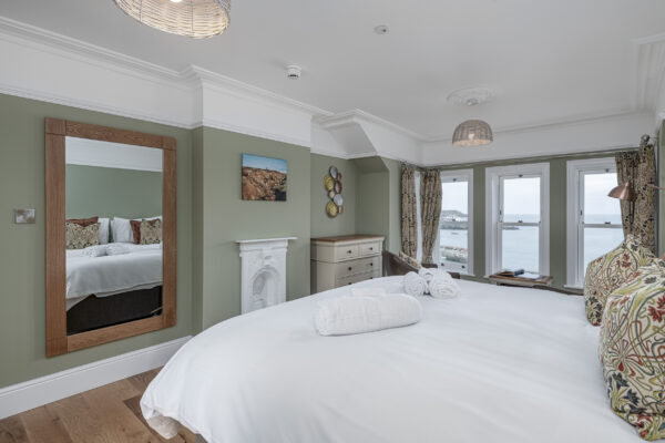 Modern bedroom interior with sea view by UK property photographer, North Wales. Elegant design with coastal scenery.