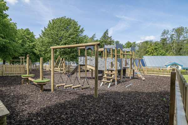Playground in a lush park photographed by UK property photographer, North Wales. Ideal for families and outdoor activities.