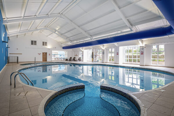 Indoor pool captured by UK property photographer in North Wales, showcasing spacious design and natural light.