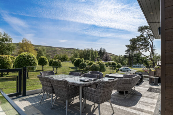 Outdoor seating in North Wales property, captured by UK property photographer, showcasing scenic landscape and modern design.