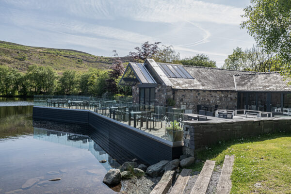 Beautiful lakeside house captured by UK property photographer, North Wales. Scenic patio and countryside view.