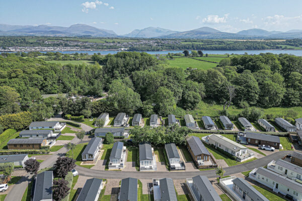 Aerial view of a picturesque UK caravan park by a North Wales property photographer, featuring lush greenery and mountains.