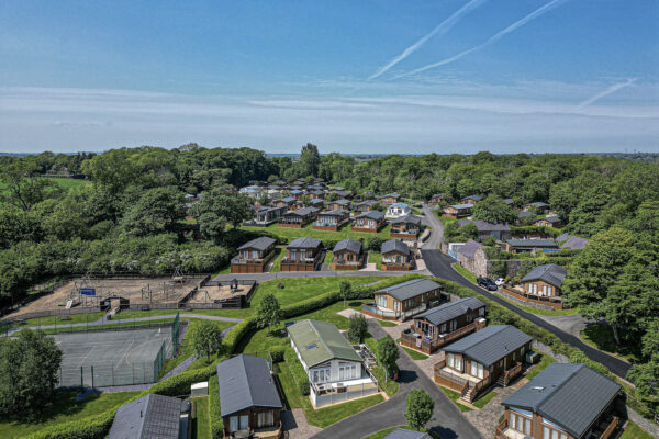 Aerial view of picturesque lodges in North Wales by UK property photographer, showcasing serene landscape and vibrant greenery.