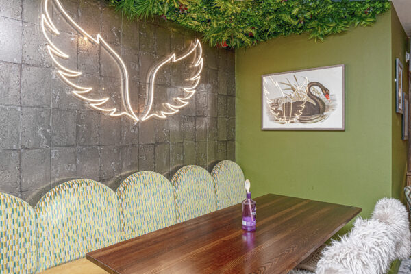 Neon wing decor in cozy dining area, captured by UK property photographer, North Wales photographer.
