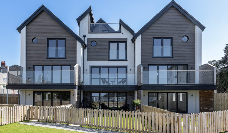 Modern UK property captured by North Wales photographer, featuring three-story building with glass balconies.